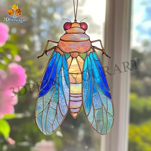 May include: Stained glass insect suncatcher with a detailed design. The insect features a brown body, red eyes, and blue and green wings. The suncatcher is designed to hang and catch the light.