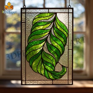 May include: Stained glass panel featuring a stylized leaf design in shades of green. The leaf is the focal point, set against a textured, clear background. The panel is framed in a dark metal and hangs from a chain. The logo "3DPrintyourart" is visible.