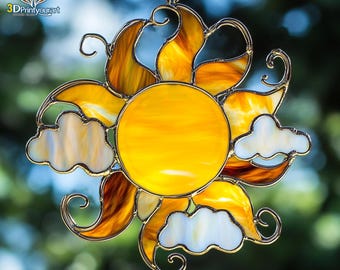 Op de afbeelding: Een zonvanger van gekleurd glas met een gele zon en witte wolken. De zon heeft een getextureerd, draaiend patroon en de wolken zijn doorschijnend. De zonvanger hangt aan een metalen lus.
