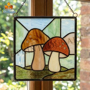 May include: Stained glass panel featuring two stylized mushrooms with brown and orange caps and cream-colored stems. The panel is framed in black and hangs from a chain. The background is a mix of green and blue glass.