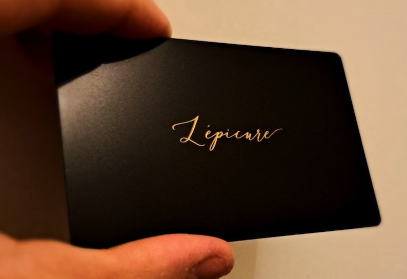 May include: A black card with gold lettering that reads 'L'epicure'