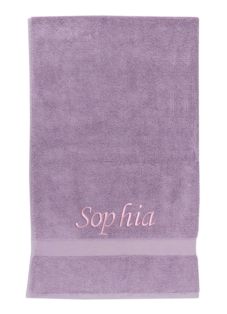 May include: A lavender-colored towel with the name "Sophia" embroidered in pink.