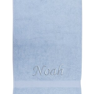 May include: A light blue towel with the name "Noah" embroidered in silver thread.