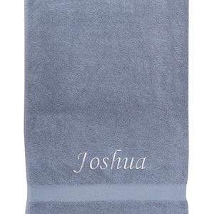 May include: A blue bath towel with the name "Joshua" embroidered in white.