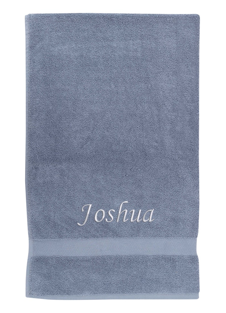 May include: A blue bath towel with the name "Joshua" embroidered in white.