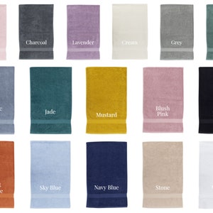 May include: A collection of 15 bath towels in various colors, including soft pink, charcoal, lavender, cream, grey, sage green, pacific blue, jade, mustard, blush pink, black, burnt orange, sky blue, navy blue, stone, and white.