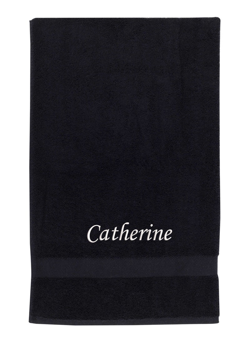 May include: A black bath towel with the name "Catherine" embroidered in white on the front.