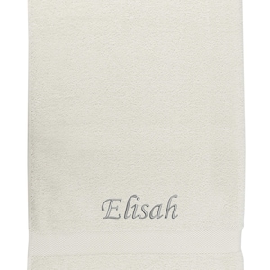 May include: A white towel with the name "Elisah" embroidered in gray cursive lettering.