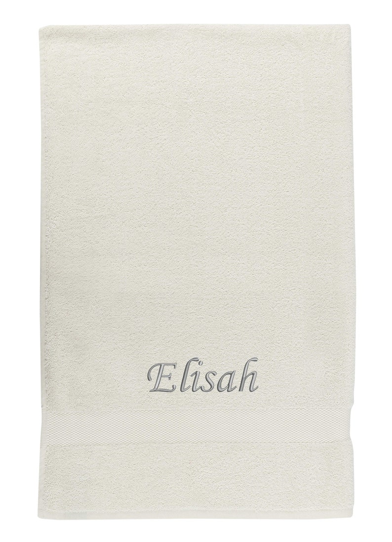 May include: A white towel with the name "Elisah" embroidered in gray cursive lettering.