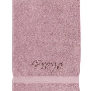 May include: A soft, pink bath towel with the name "Freyja" embroidered in a cursive font.