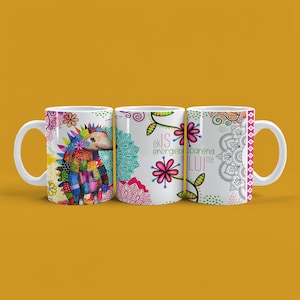 Pode incluir: Três canecas de cerâmica branca com designs coloridos. Uma caneca apresenta um ouriço de patchwork, outra tem detalhes florais e texto, e a terceira exibe um padrão de mandala. As canecas têm alças brancas e estão sobre um fundo amarelo.