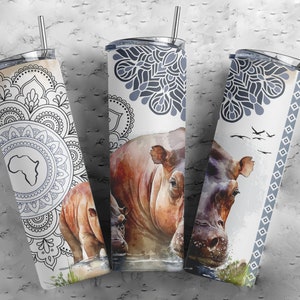 May include: Three stainless steel tumblers with a white background and a design featuring a hippopotamus, mandala patterns, and a silhouette of the continent of Africa.