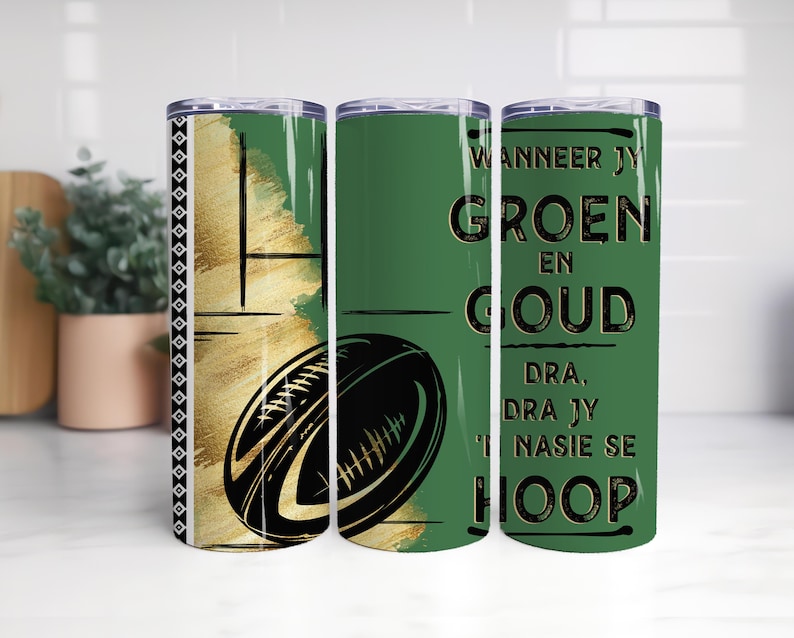 May include: A set of three stainless steel tumblers. The tumblers feature a green and gold design with a rugby ball graphic. One tumbler has text in black. The tumblers are designed for cold beverages.