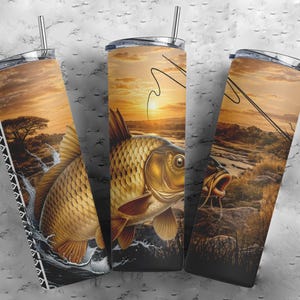 Puede incluir: Tres vasos cilíndricos con pajitas de metal que presentan un gráfico continuo de una carpa dorada saltando fuera del agua al atardecer. El diseño incluye la silueta de una caña de pescar, un paisaje fluvial y un borde geométrico en blanco y negro.