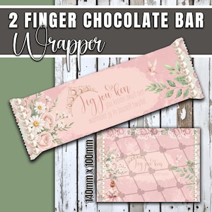 May include: A pink chocolate bar wrapper with floral and pearl accents. The wrapper features text in a script font and a smaller matching design. The dimensions are 140mm x 100mm.