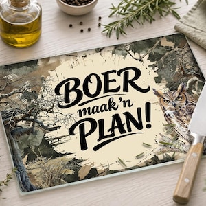 Peut inclure: Une planche à découper rectangulaire en verre avec un centre crème portant le texte noir BOER maak'n PLAN! entouré d'une scène de forêt détaillée avec des arbres et un hibou perché, accompagnée d'un couteau de cuisine au manche en bois clair.