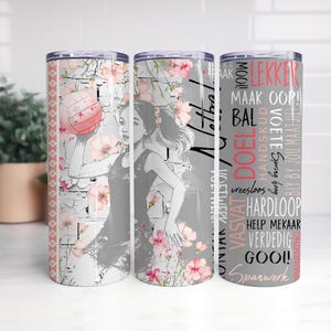 Może przedstawiać: Trzy kubki ze stali nierdzewnej z motywami siatkówki. Każdy kubek przedstawia ilustrację siatkarza, kwiatowe akcenty i tekst w układzie pionowym. Paleta kolorów obejmuje róż, szary i biały.