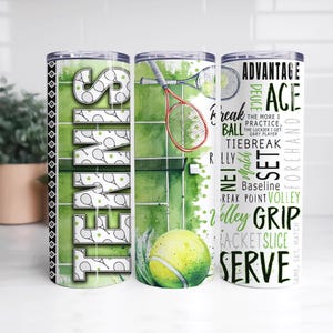 May include: Three stainless steel insulated tumblers with tennis-themed designs. One tumbler features the word "TENNIS" in green and white. Another shows a tennis court with a ball and racket. The third has tennis terms like "ACE" and "SERVE".