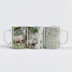 Puede incluir: Taza de cerámica blanca con un diseño de acuarela verde y marrón de un rinoceronte y un ñu en un entorno de sabana. La taza tiene un borde negro y texto en verde y marrón que dice "SKOFFEL MISKRUIER natuur khoki brou us BOER KRAAL TROTS BRAAI MOERKOFFIE BID MOS MELKKOS Lag POTJIEKOS SAAS VAN PIAAS HOKAAI! triller STUUR ONS NET SO BIETJIE REEN".