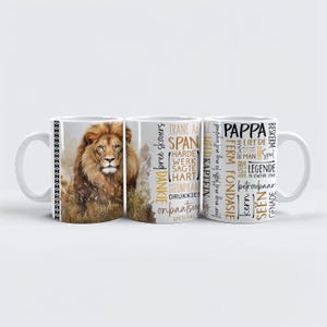May include: White ceramic mug featuring a detailed illustration of a lion with a golden mane. The mug has text in multiple languages, including "Pappa" and "Legend". The mug has a black and white geometric pattern on the handle.