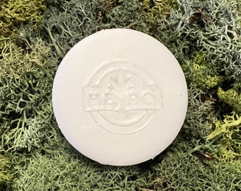May include: White round soap bar with a raised design of a cannabis leaf and the word "HEMP" in a circle.