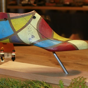 colored shoe lasts in harlequin style on beechwood stand