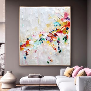 Puede incluir: Pintura abstracta con fondo blanco y pinceladas coloridas en tonos de rosa, amarillo, azul, verde y rojo. La pintura tiene un aspecto texturizado y está enmarcada en un marco dorado.