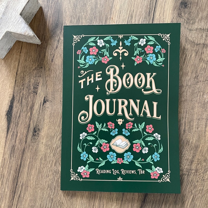 K&ouml;nnte beinhalten: Ein gr&uuml;nes Buchjournal mit floralem Design und goldener Schrift. Der Titel lautet "The Book Journal" und der Untertitel lautet "Reading Log, Reviews, TBR".