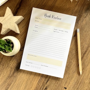 May include: A printable book review template with sections for book title, author, genre, theme, thoughts, favourite quote, date started, date finished, and rating. The template has a simple design with black text on a white background.