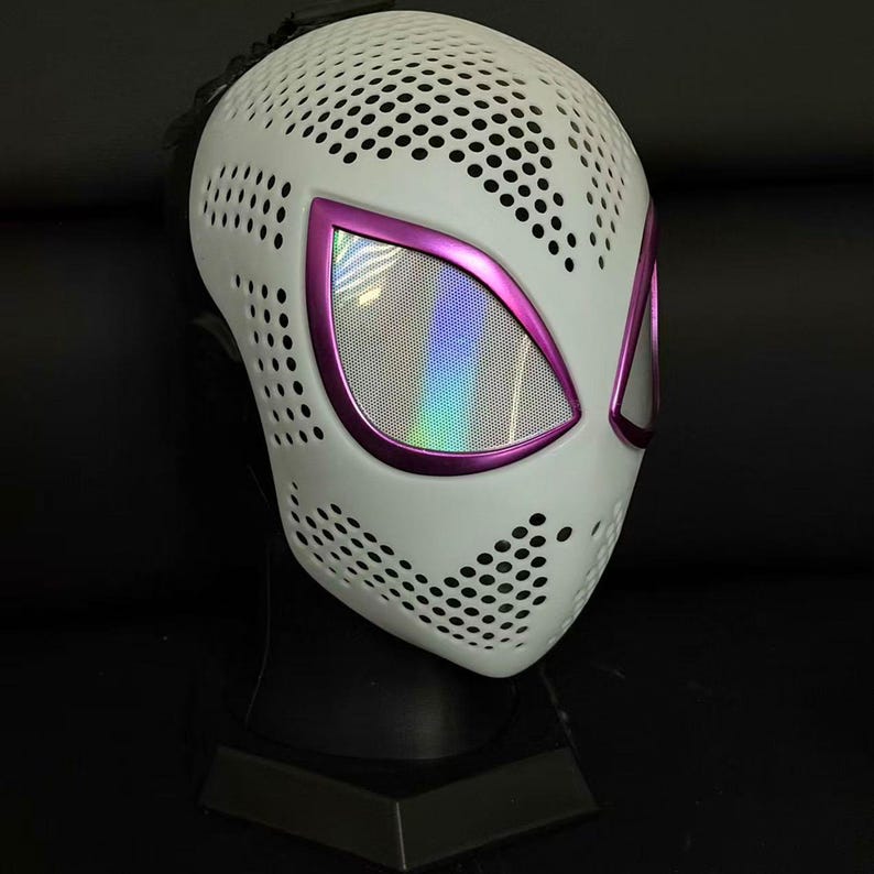 May include: White mask with a perforated pattern, featuring purple-edged eye openings with a holographic effect. The mask is designed with a superhero theme, suitable for cosplay or costume events.