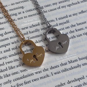 May include: Two heart-shaped padlock pendants on thin metal chains, one in gold tone and one in silver tone. Each pendant features a central keyhole cutout, the engraved text "for keeps," and four small star-shaped accents on the surface.