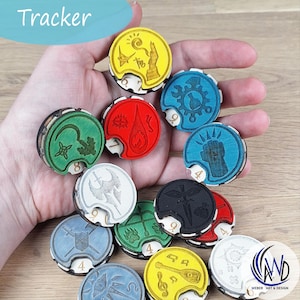 Może przedstawiać: Kolekcja drewnianych żetonów do śledzenia gier w różnych kolorach, w tym żółtym, czerwonym, zielonym i niebieskim. Każdy żeton ma unikalny grawerowany symbol i numer. Słowo "Tracker" znajduje się w lewym górnym rogu.