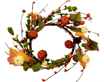 May include: A fall-themed wreath featuring miniature orange and white pumpkins, green leaves, and red berries. The wreath is circular and made of twigs, perfect for autumn decor. Includes pinecones and colorful fall foliage.