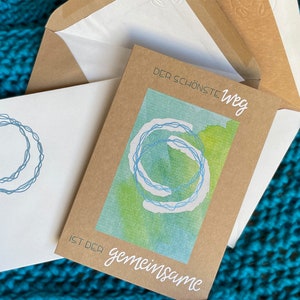 Glückwunschkarte zu Hochzeit, Verlobung. Der schönste Weg. Ringe Türkis schimmernd. Kraftpapier Klappkarte Weißdruck. verzierter Umschlag.