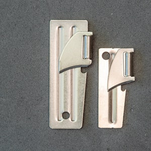 May include: Two silver can openers, one larger than the other, are shown against a gray background. Both openers have a blade and a bottle opener.