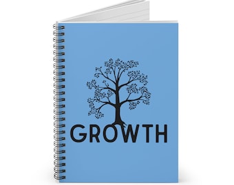 May include: A light blue spiral-bound notebook featuring a black graphic of a tree centered on the front cover. Below the tree, the word GROWTH is printed in bold, black, sans-serif capital letters. The notebook is shown slightly open at the top.
