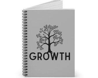 May include: A light gray spiral-bound notebook featuring a black graphic of a tree centered on the front cover. Below the tree, the word GROWTH is printed in bold, black, sans-serif capital letters. The notebook is shown slightly open.