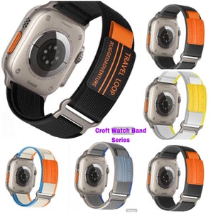 May include: Five different color variations of a black watch band with orange, yellow, blue, and white accents. The band has the text "TRAVEL LOOP" and "RUGGEDADVENTURE" printed on it. The band is designed for a smart watch.