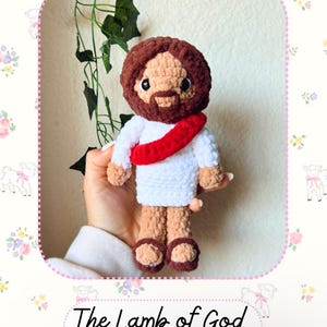 May include: Crocheted plush toy of Jesus, the Lamb of God, with a red sash and brown hair. The toy is holding a white crocheted robe and has brown sandals. The text "The Lamb of God" and "Jesus" is written below the toy. The text "@nickimontescco" is written below the text "Jesus".