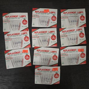 May include: Nine packages of replacement lamps for single flasher lite sets. Each package has a red and white design with the text "Replacement Lamps" and a Christmas ornament graphic. The packages contain 5 lamps each.