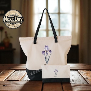 A white tote bag with a black handle and a smaller white bag with a black handle are placed on a wooden surface, with a window and a sign for Next Day Shipping in the background.