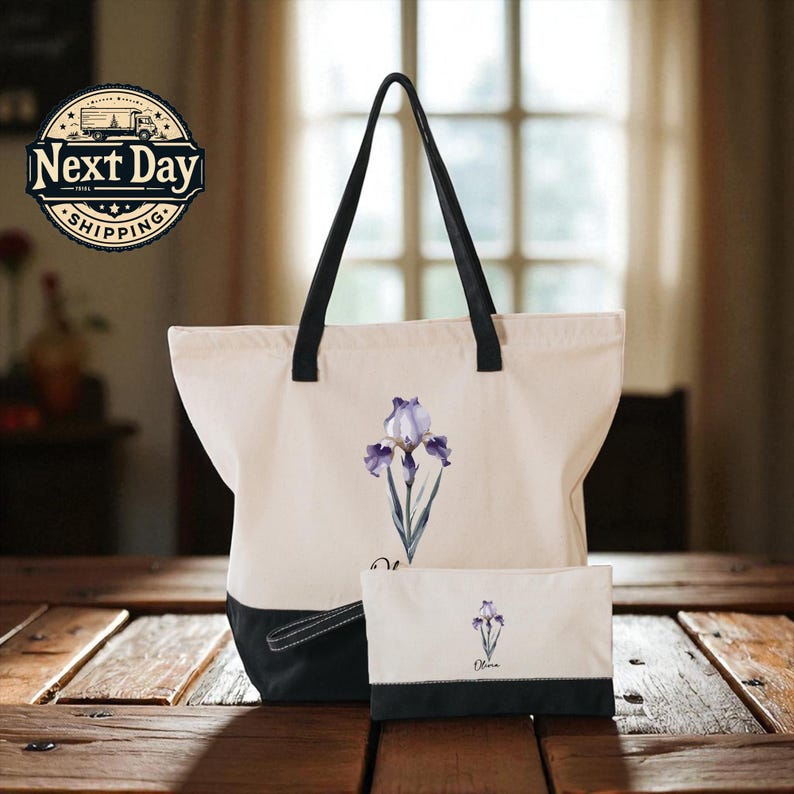 A white tote bag with a black handle and a smaller white bag with a black handle are placed on a wooden surface, with a window and a sign for Next Day Shipping in the background.