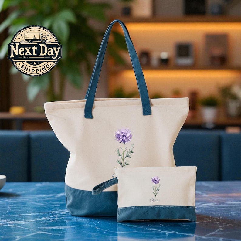 A beige tote bag with a blue handle and a smaller white bag with a purple flower design are placed on a blue marble countertop.