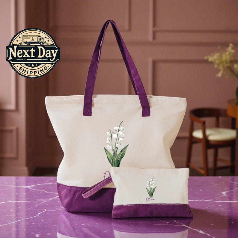 A large white tote bag with purple accents and a smaller white bag with a purple trim, both featuring a lily of the valley design, are displayed on a purple marble countertop.