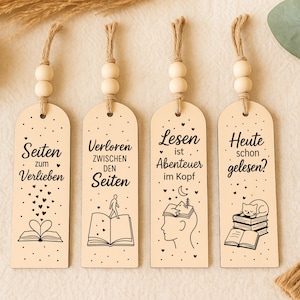 May include: Set of four wooden bookmarks with decorative text and illustrations. Each bookmark has a different design, including open books, hearts, and a cat. They are strung with twine and wooden beads.
