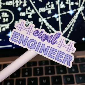 May include: A purple and white sticker with the text "civil ENGINEER" and a stylized image of a bridge. The sticker is on a white pen, which is on a laptop keyboard.