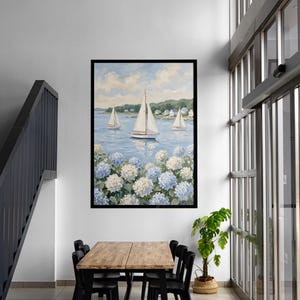 May include: A framed painting of sailboats on a blue sea, with white and blue hydrangeas in the foreground. The artwork is displayed in a modern interior with a wooden table and black chairs.