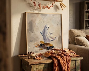 Op de afbeelding: Een vierkant ingelijst schilderij met een witte geest met een eenvoudig lachend gezicht op een houten skateboard. De achtergrond heeft getextureerde, neutrale penseelstreken. Het kunstwerk staat op een houten tafel met herfstbladeren.