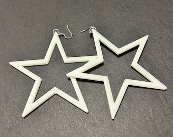 May include: A pair of white star-shaped earrings with a silver hook closure.