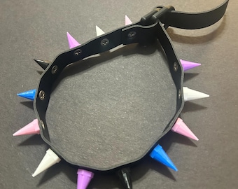 May include: A black leather choker with a silver buckle and spikes in various colors, including white, blue, purple, and black.